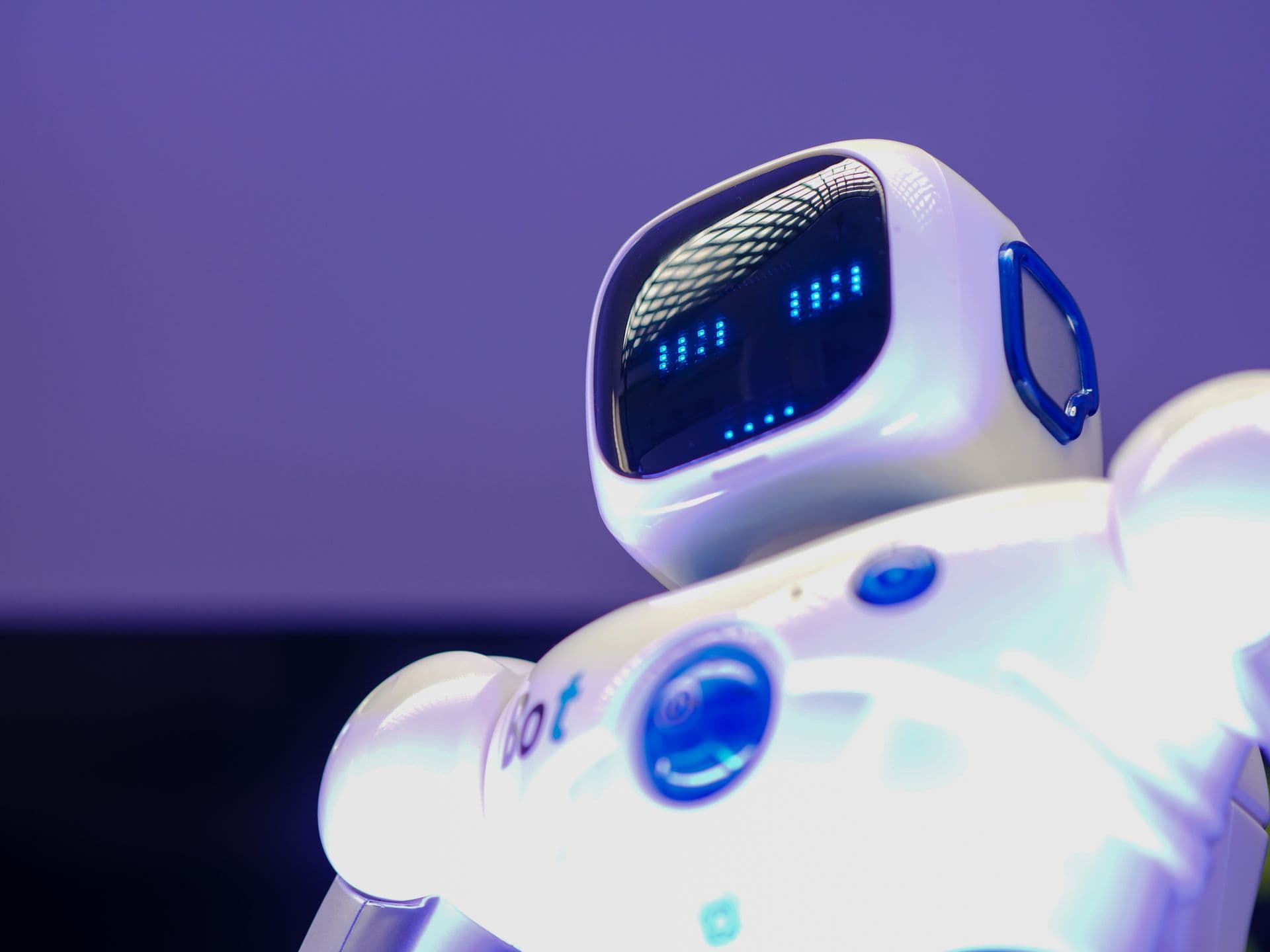 Friendly white robot with a glowing digital face representing an AI assistant